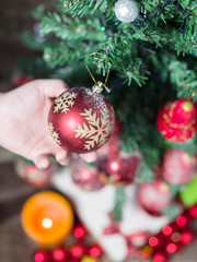 Close-up of man hanging decorative toy ball on Christmas tree br