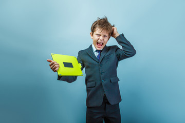 Teen  boy of twelve European appearance in a business suit holdi