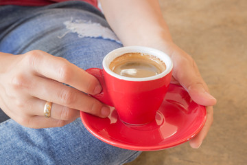 Woman in torn jeans sitting at coffee shop