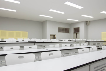 clean class room with white chairs and tables