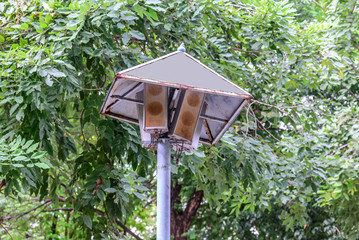 Rusty speakers with rainproof roof for announcement broadcasting.