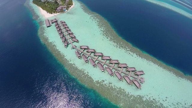 AERIAL: Luxurious over-water villas on tropical island resort