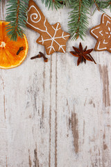 Decorated gingerbread, spruce branches, spices on old wooden background, christmas decoration