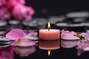 Still life with pink rose petals with pink candle and therapy stones 