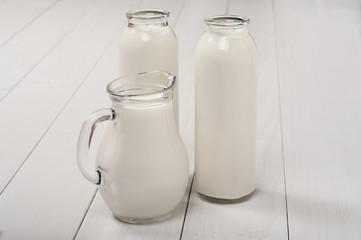 Milk bottles and decanter on a wooden table