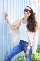 fashion model with long curly hair wearing sunglasses posing out