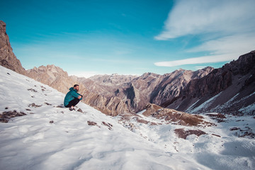 Man standing at a top of a mountain covered with snow
