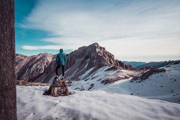 Man standing at a top of a mountain covered with snow