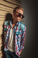 blonde man posing in studio with hands in pockets