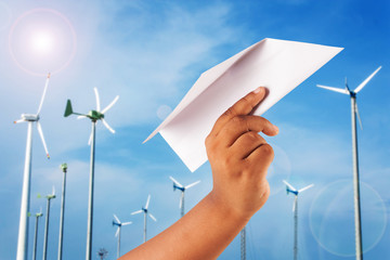 hand boy play paper plane on wind turbine background