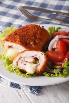 Delicious sliced Chicken cordon bleu and a salad close-up. Vertical
