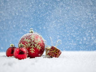 Red christmas ball with gift on snow