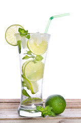 Mojito cocktail with lime on wooden table