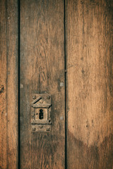 Old vintage wood cellar door with rusty keyhole