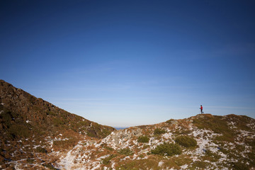 Silhouette of woman running along the ridge.