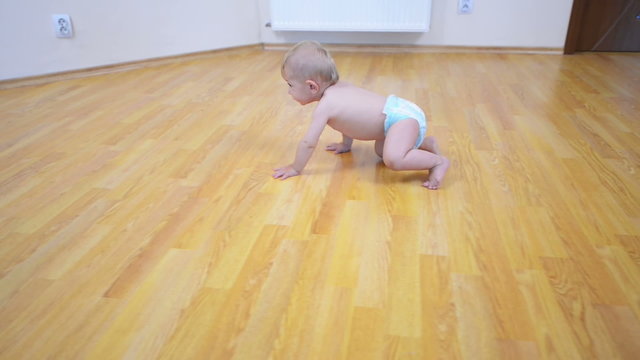Happy baby go on all fours on the floor at home