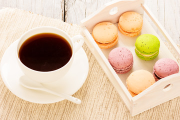 Set of various colored macaroons on wooden plate