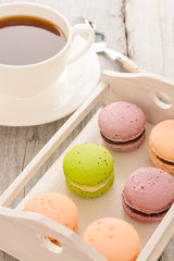 Set of various colored macaroons on wooden plate