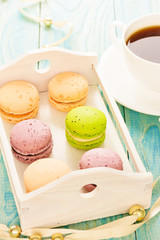Set of various colored macaroons on wooden plate