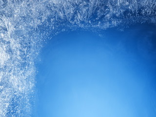 Frosty patterns on the edge of a frozen window.