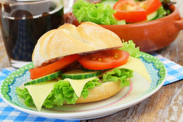Bread roll with cheese, tomato, cucumber and lettuce, closeup
