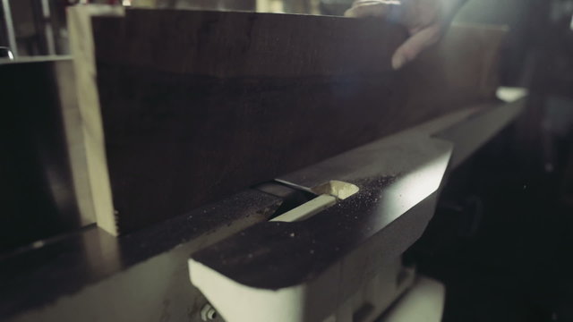 joiner processing the workpiece of wooden plank by jointing machine