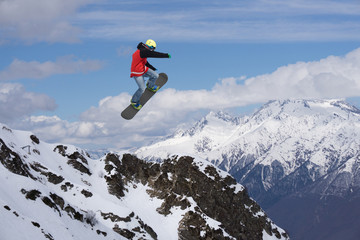 Flying snowboarder on mountains. Extreme sport