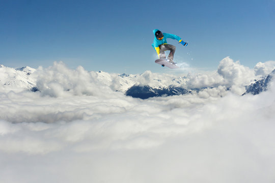 Flying snowboarder on mountains. Extreme sport