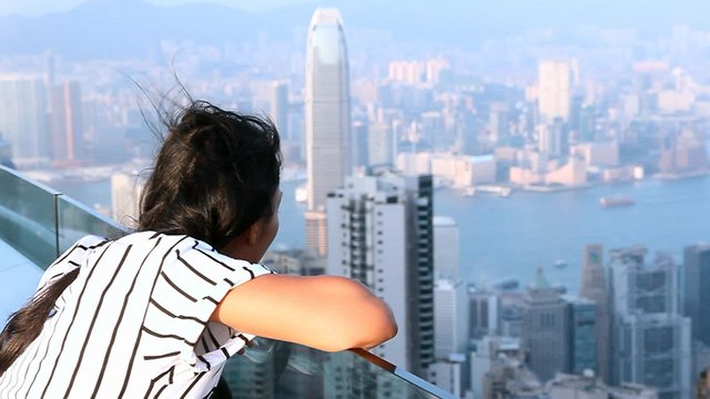 woman watching sunset over Victoria Harbor as viewed from top of Victoria Peak