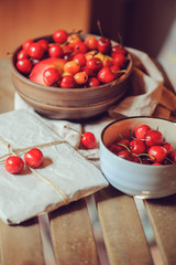 fresh ripe cherries on plate with wrapped gift on wooden table