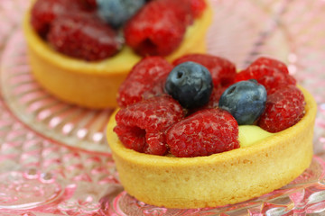 Crunchy and creamy tartelette with raspberries and blueberries, closeup
