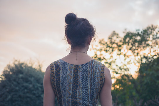 Rear view of young woman at sunset