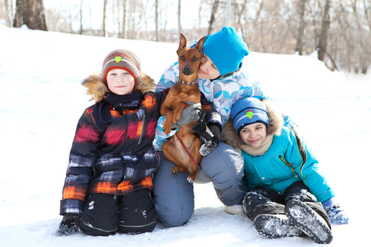 Mother with children and a dog walking in the winter on walk