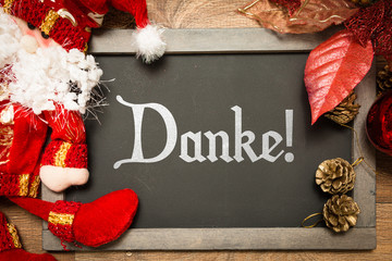 Blackboard with the text: Thank You (in German) in a christmas conceptual image