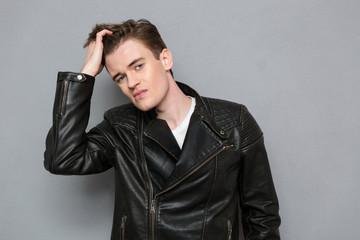 Man in leather jacket touching his hair