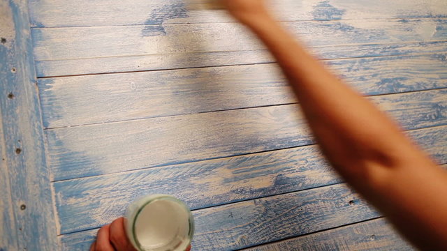 An accelerated footage of a wooden board being coloured white as a background for still life photos
