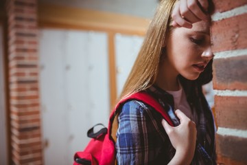 Worried student leaning against the wall
