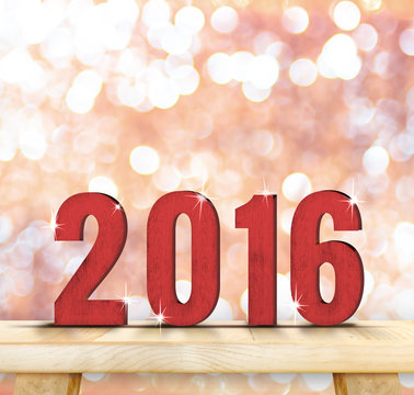 Red 2016 year wood number on wooden table top with sparkling pin