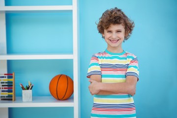 Smiling boy standing beside some toys