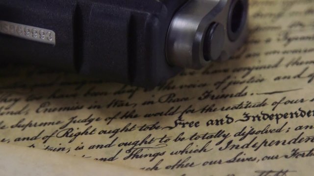 US Constitution Bill of Rights with hand gun - History of the Second Amendment