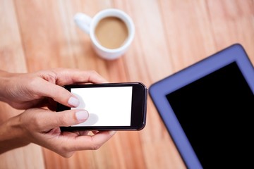 Overhead of feminine hands using smartphone