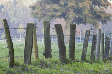 A wooden fence with barbed wire