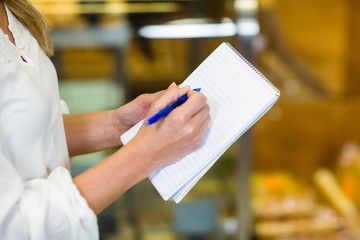 Woman checking list at supermarket