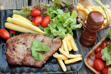 Pork steak of delicious with vegetable and tomato.