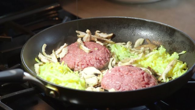 Cooking hamburger meat ground beef in hot frying pan on stovetop