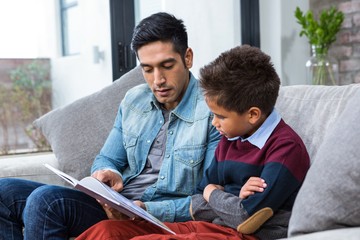 Happy father reading book with his son