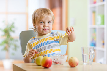 child eating healthy food with a spoon at home