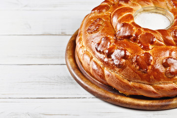 Russian wedding round loaf close-up on wooden table. Wedding bread with salt. Russian wedding ceremony 