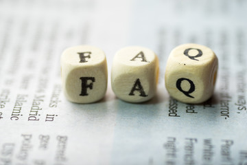 Wooden blocks with the text, FAQ on the newspaper