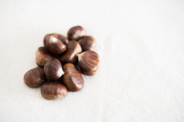 Raw whole brown chestnuts heap